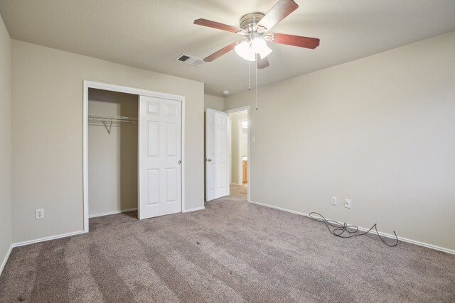 unfurnished bedroom with ceiling fan, carpet, and a closet