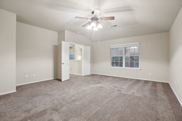 unfurnished bedroom featuring ceiling fan, vaulted ceiling, and carpet