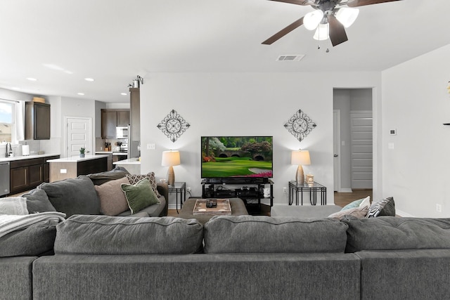 living room with ceiling fan, hardwood / wood-style floors, and sink