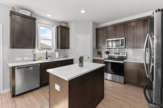 232 Syrah Ct, Leander, TX 78641 - kitchen featuring stainless steel appliances, a sink, light wood-style flooring, dark brown cabinets, and recessed lighting
