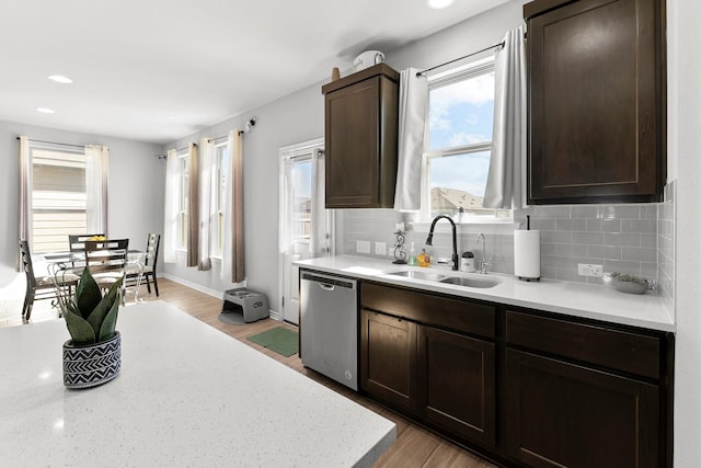 kitchen with dishwasher, tasteful backsplash, light hardwood / wood-style flooring, and sink