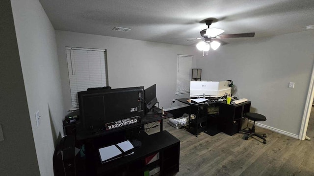 office featuring wood finished floors, a ceiling fan, and baseboards