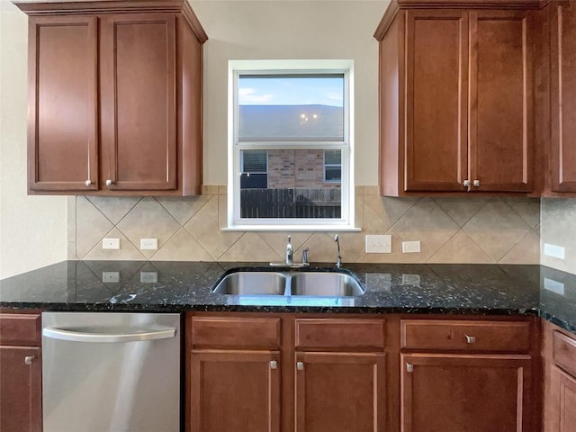 kitchen featuring backsplash, dark stone countertops, dishwasher, and sink