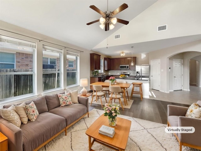 living room with ceiling fan, high vaulted ceiling, and light hardwood / wood-style floors