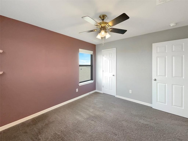 unfurnished bedroom featuring ceiling fan and dark colored carpet