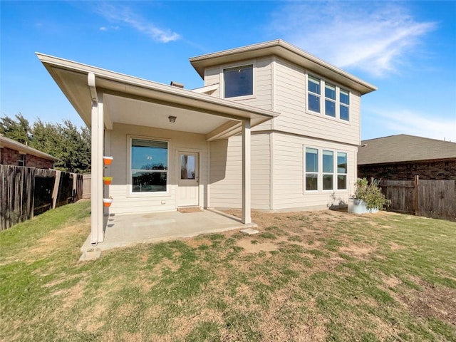 back of house with a lawn and a patio area