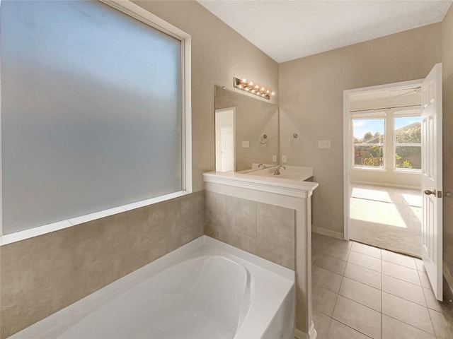 bathroom with a tub to relax in, tile patterned flooring, and vanity