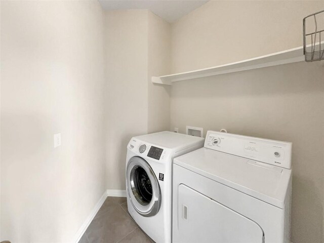 washroom featuring tile patterned flooring and washing machine and dryer