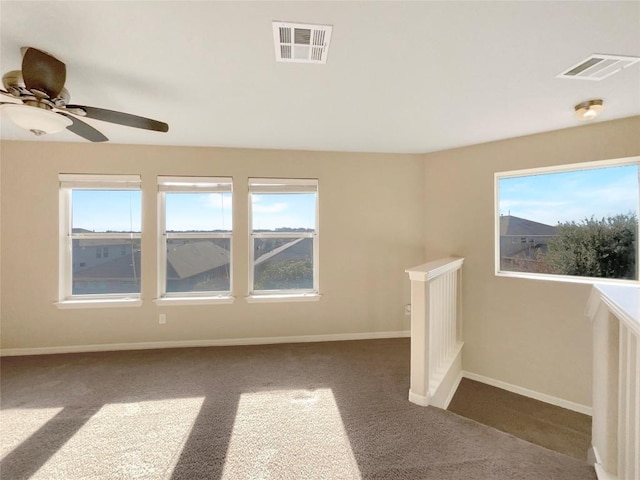 interior space with ceiling fan, plenty of natural light, and dark colored carpet