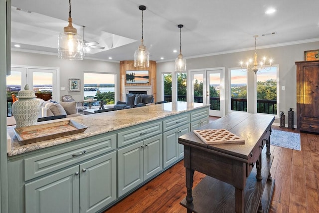 kitchen with dark wood-type flooring, open floor plan, french doors, ornamental molding, and light stone countertops