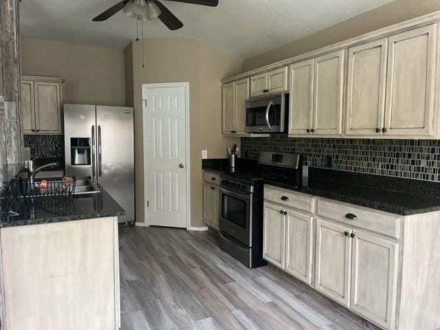 kitchen with backsplash, ceiling fan, sink, and stainless steel appliances