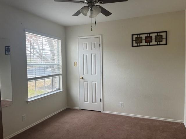 carpeted spare room with ceiling fan