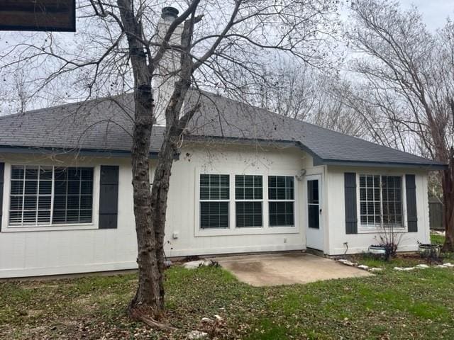 back of house featuring a lawn and a patio