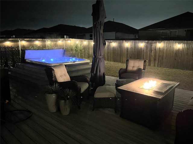 deck at night featuring an outdoor fire pit