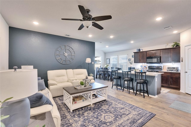 living room featuring ceiling fan and light hardwood / wood-style flooring