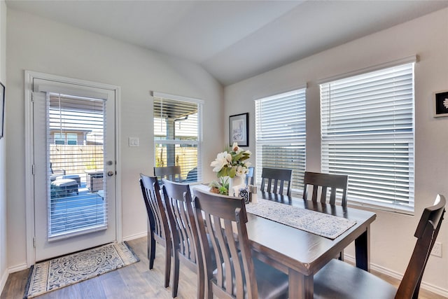 dining space featuring light hardwood / wood-style floors and vaulted ceiling