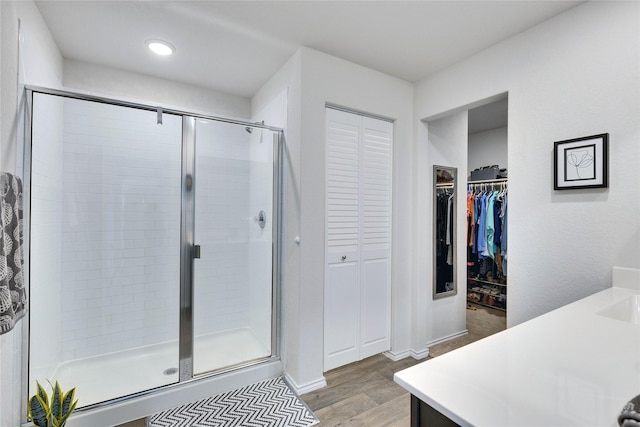 bathroom with wood-type flooring, vanity, and an enclosed shower