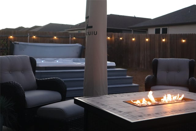 view of patio with a covered hot tub and a fire pit