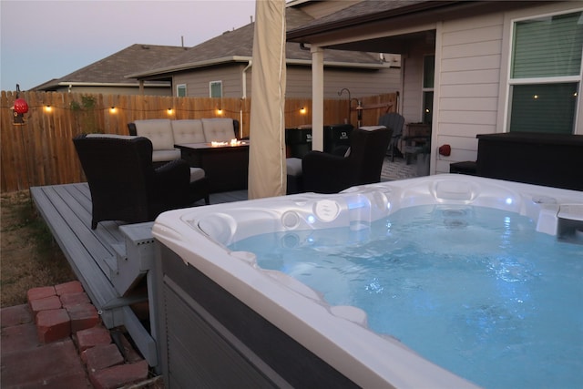 patio terrace at dusk featuring outdoor lounge area and a hot tub