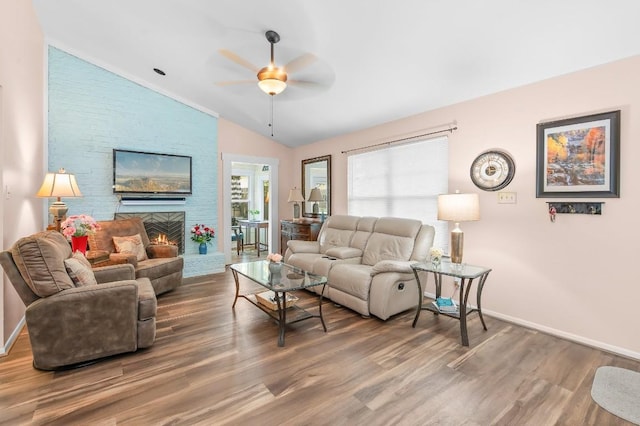 living room with a fireplace, ceiling fan, hardwood / wood-style floors, and vaulted ceiling