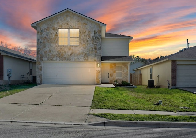 front of property featuring a yard, a garage, and central air condition unit