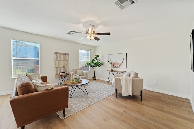 living room with ceiling fan and light hardwood / wood-style flooring