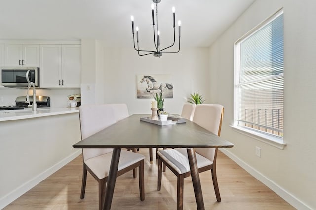 dining space with a notable chandelier, light hardwood / wood-style floors, and a wealth of natural light