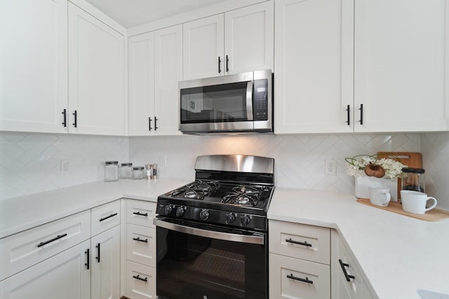 kitchen featuring stainless steel appliances, white cabinetry, and tasteful backsplash