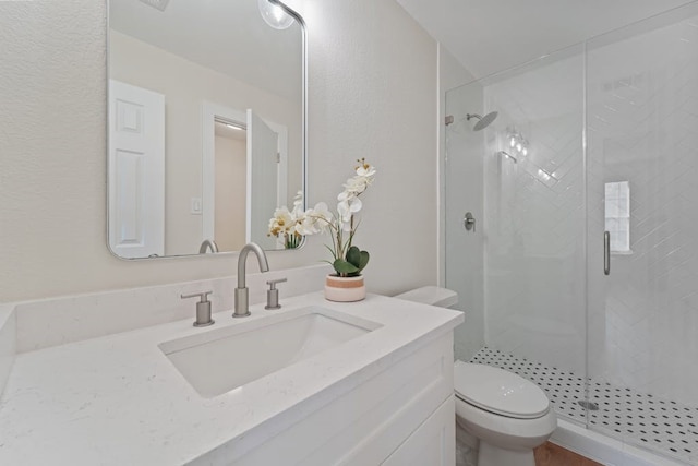 bathroom with vanity, toilet, and a shower with door