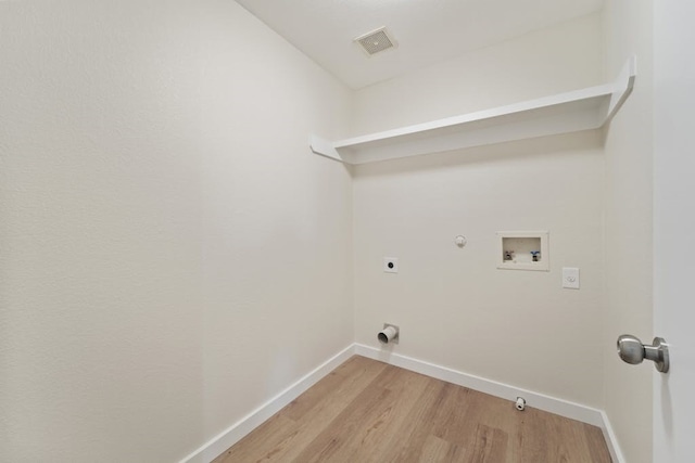 clothes washing area featuring gas dryer hookup, light hardwood / wood-style flooring, washer hookup, and hookup for an electric dryer