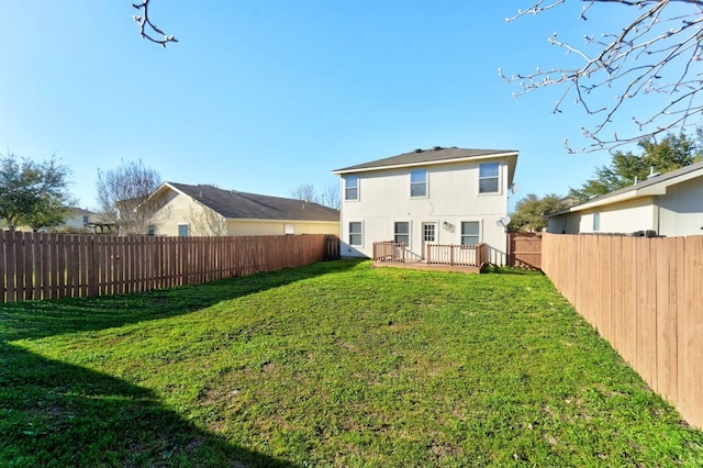 rear view of house featuring a deck and a lawn