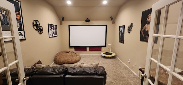 home theater featuring carpet, french doors, and vaulted ceiling