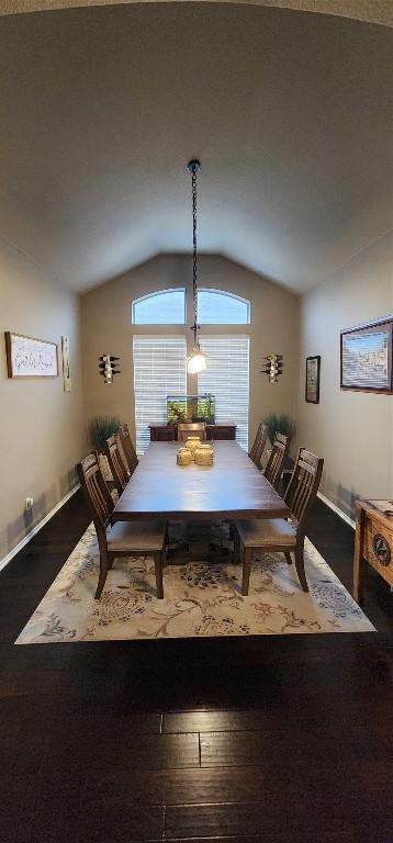 dining space with hardwood / wood-style floors and vaulted ceiling