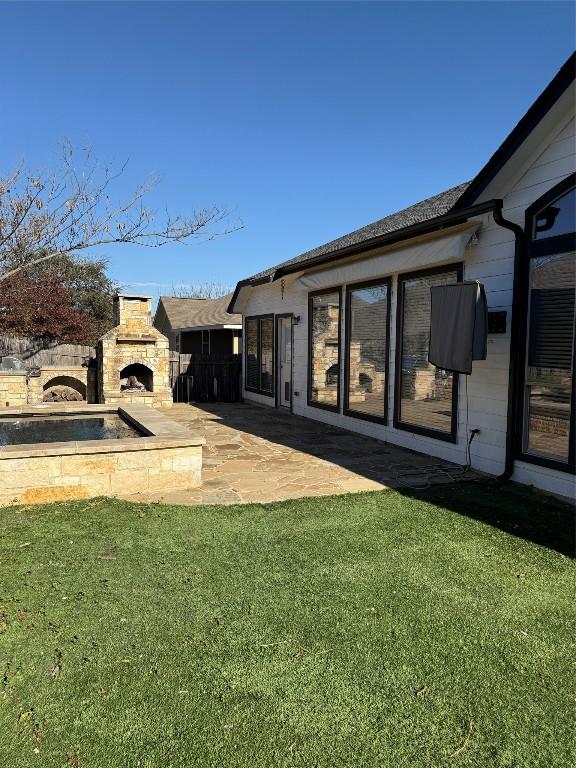 view of yard featuring a patio area and an outdoor fireplace