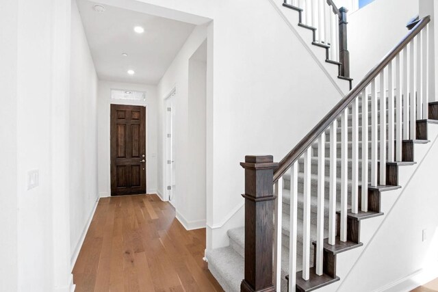 entrance foyer featuring recessed lighting, baseboards, stairway, and hardwood / wood-style floors