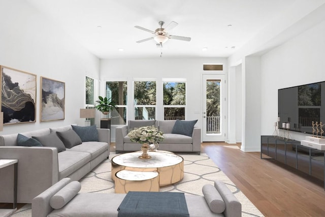 living room with wood finished floors, a ceiling fan, and baseboards