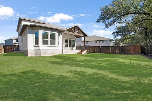 back of house featuring a yard, central AC, a fenced backyard, and stucco siding