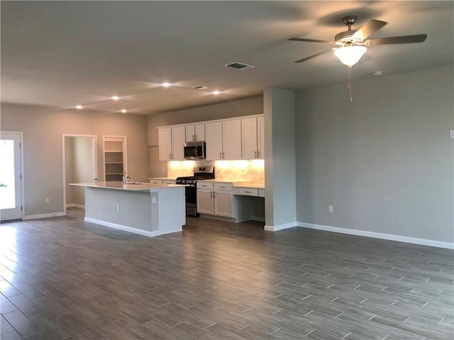 kitchen with white cabinets, a center island, stainless steel appliances, and ceiling fan