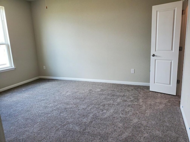 unfurnished room with dark colored carpet