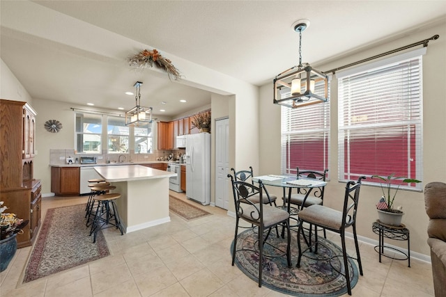 tiled dining area featuring sink and an inviting chandelier