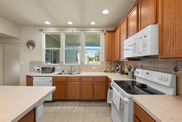 kitchen featuring decorative backsplash, white appliances, sink, and light tile patterned floors