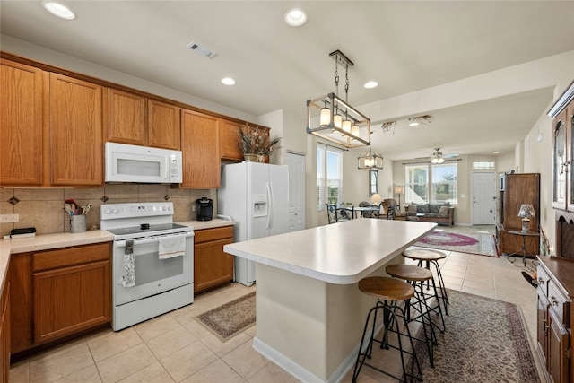 kitchen featuring decorative backsplash, white appliances, ceiling fan, pendant lighting, and a center island