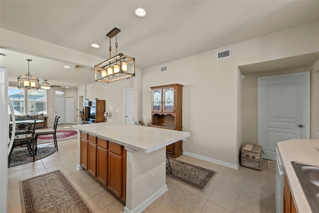 kitchen with pendant lighting, light tile patterned floors, a kitchen island, and ceiling fan