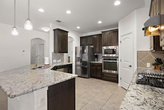 kitchen featuring backsplash, appliances with stainless steel finishes, sink, and pendant lighting