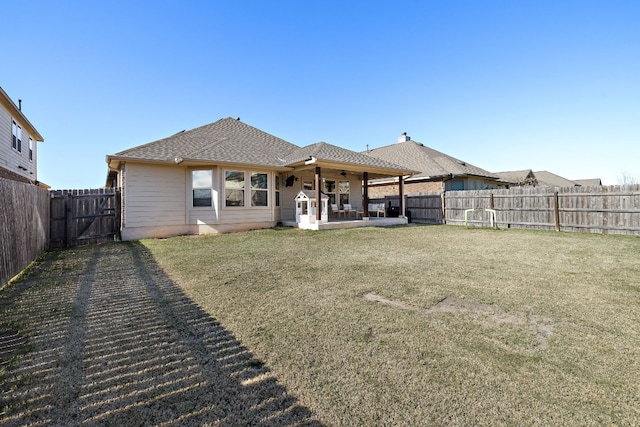 back of property featuring ceiling fan, a lawn, and a patio