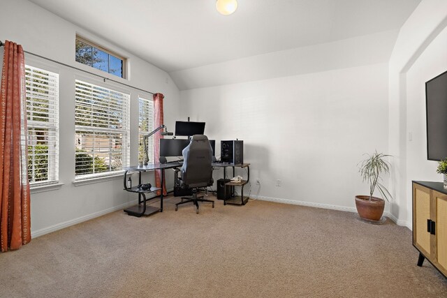 carpeted home office with lofted ceiling