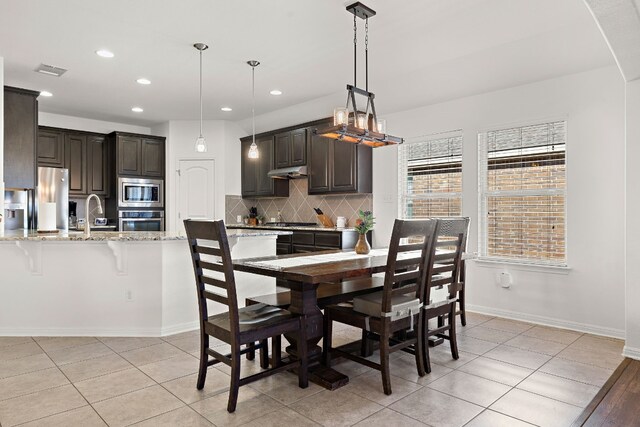 tiled dining room featuring sink