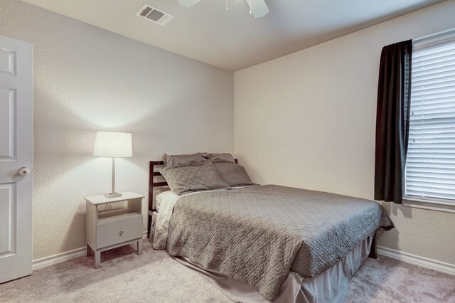 carpeted bedroom featuring visible vents, ceiling fan, and baseboards