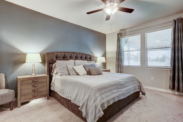 bedroom with baseboards, a ceiling fan, and light colored carpet