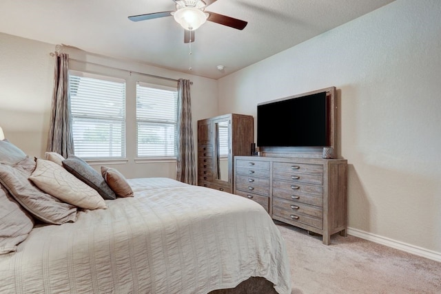 bedroom featuring baseboards, ceiling fan, and light colored carpet